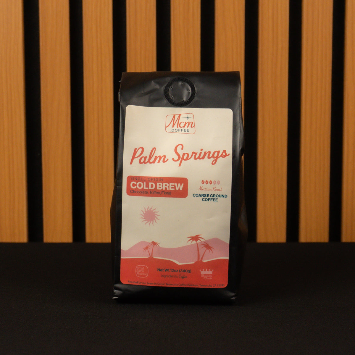 Coffee bag labeled 'Palm Springs Cold Brew' by Mimi Coffee against a striped background